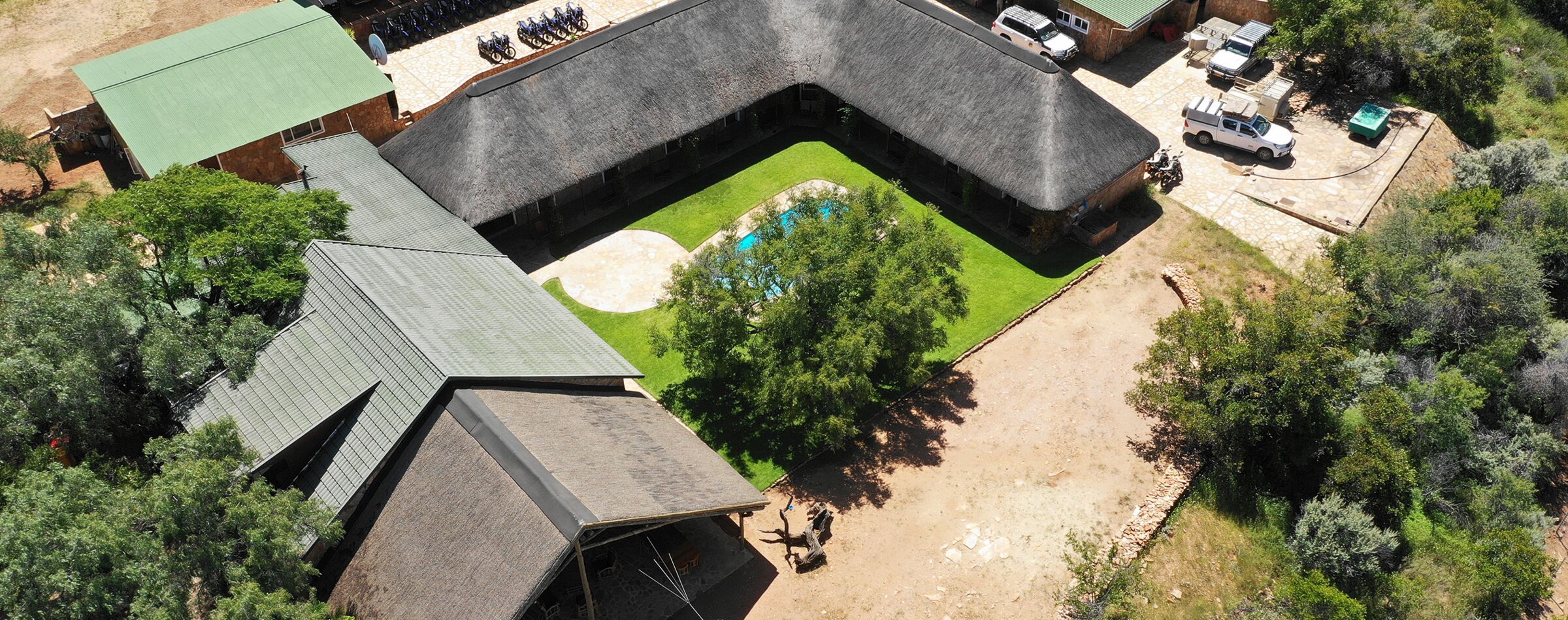 Aerial view of Windhoek Mountain Lodge with a pool, surrounded by nature – the basecamp for Gravel Travel adventures.