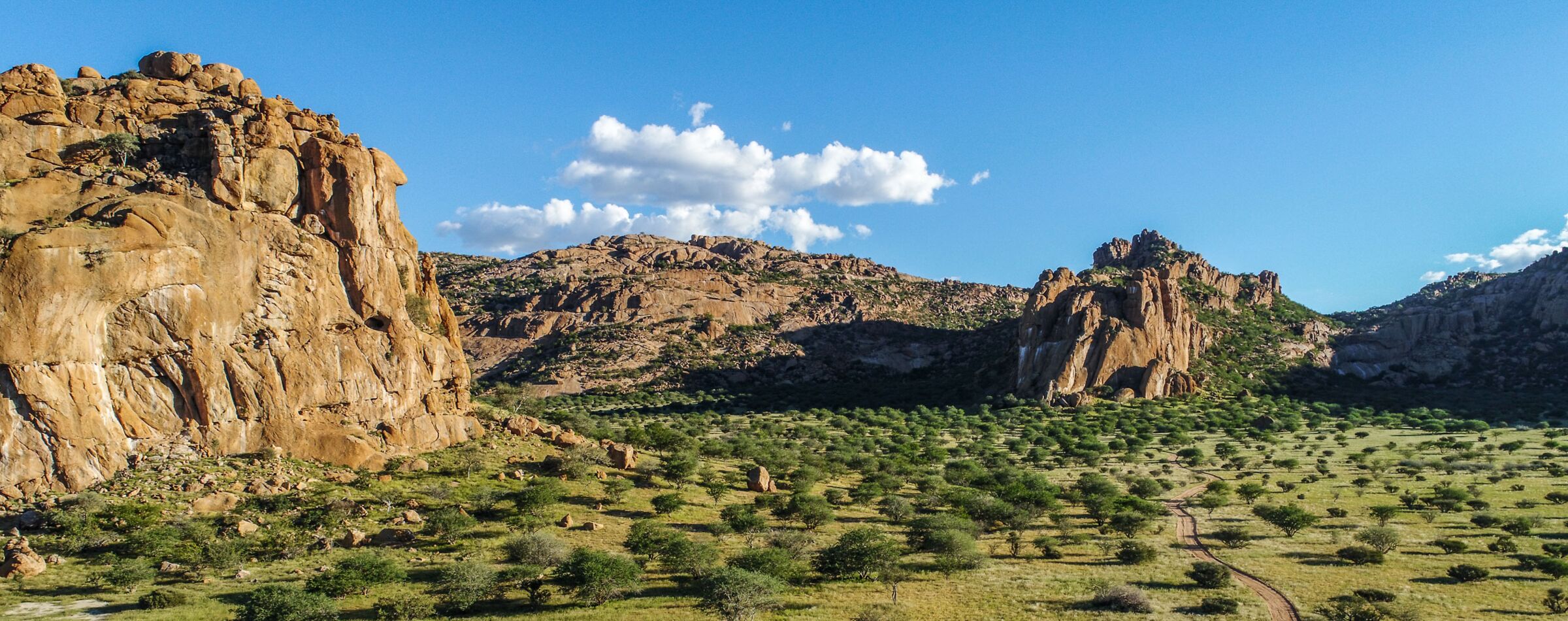 Majestic rock formations and lush green valley in Namibia, captured on a Gravel Travel adventure through Southern Africa.