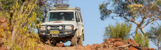 A rugged 4x4 off-road vehicle conquers a rocky trail, surrounded by pristine nature and wild landscapes.